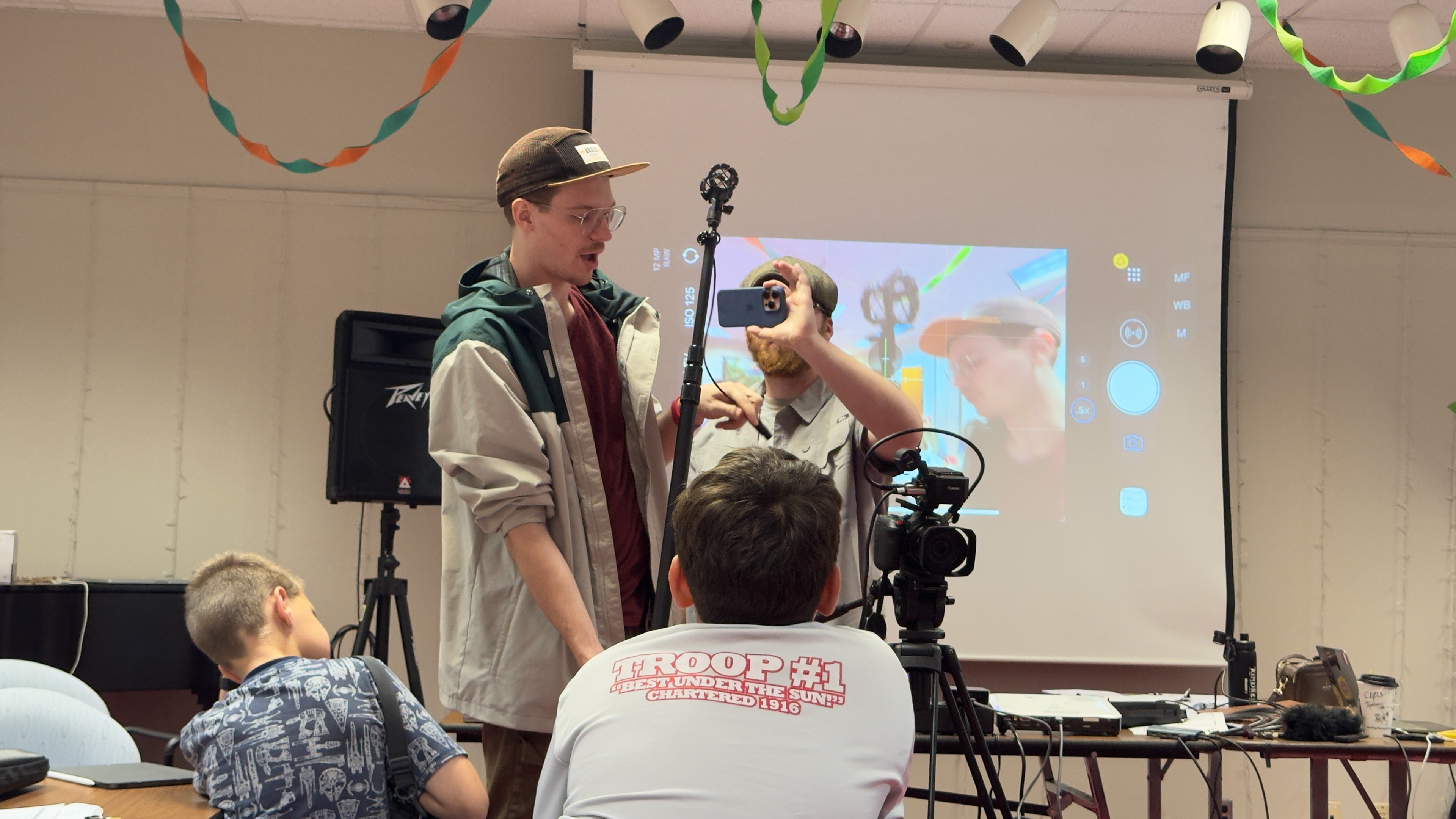 Demonstrating a boom microphone and camera setup in a classroom